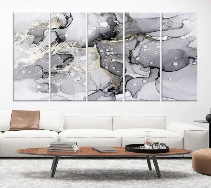 The "Marble Fluid Effect Wall Art Abstract Canvas Wall Art Print" forms a stunning abstract triptych with black, gray, and gold patterns in a modern living room. These museum-quality pieces include a UV-protective coating to ensure lasting beauty.