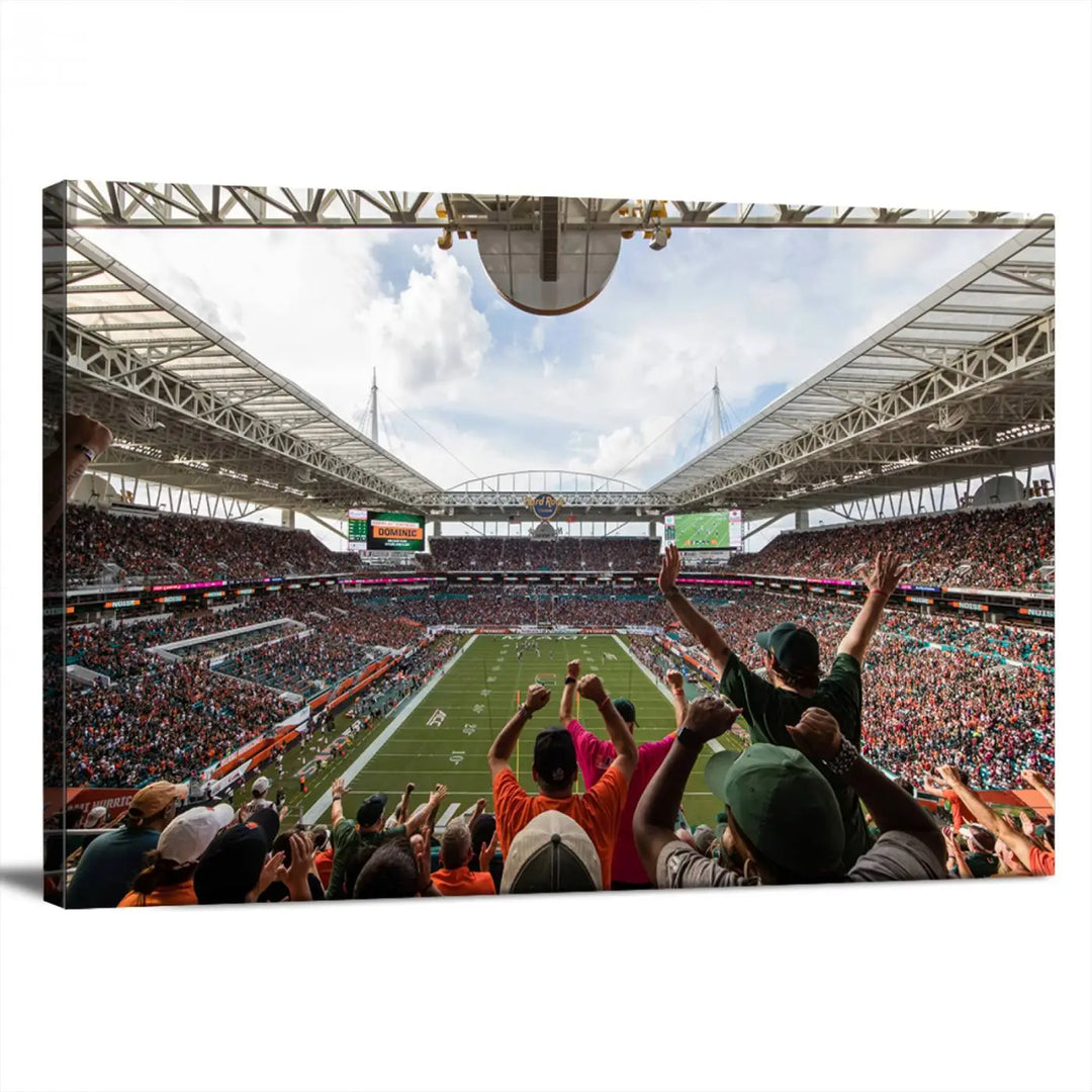 The living room features handmade triptych wall art crafted in the USA, depicting a cheering crowd at a Miami Hurricanes football game. The artwork showcases the Miami Hard Rock Stadium on premium canvas.