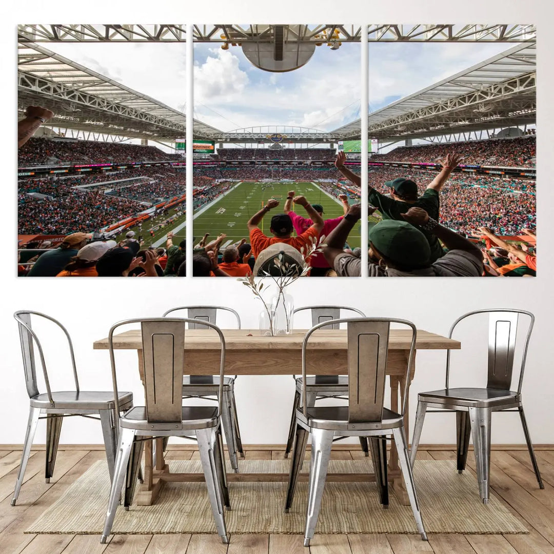 The living room features handmade triptych wall art crafted in the USA, depicting a cheering crowd at a Miami Hurricanes football game. The artwork showcases the Miami Hard Rock Stadium on premium canvas.