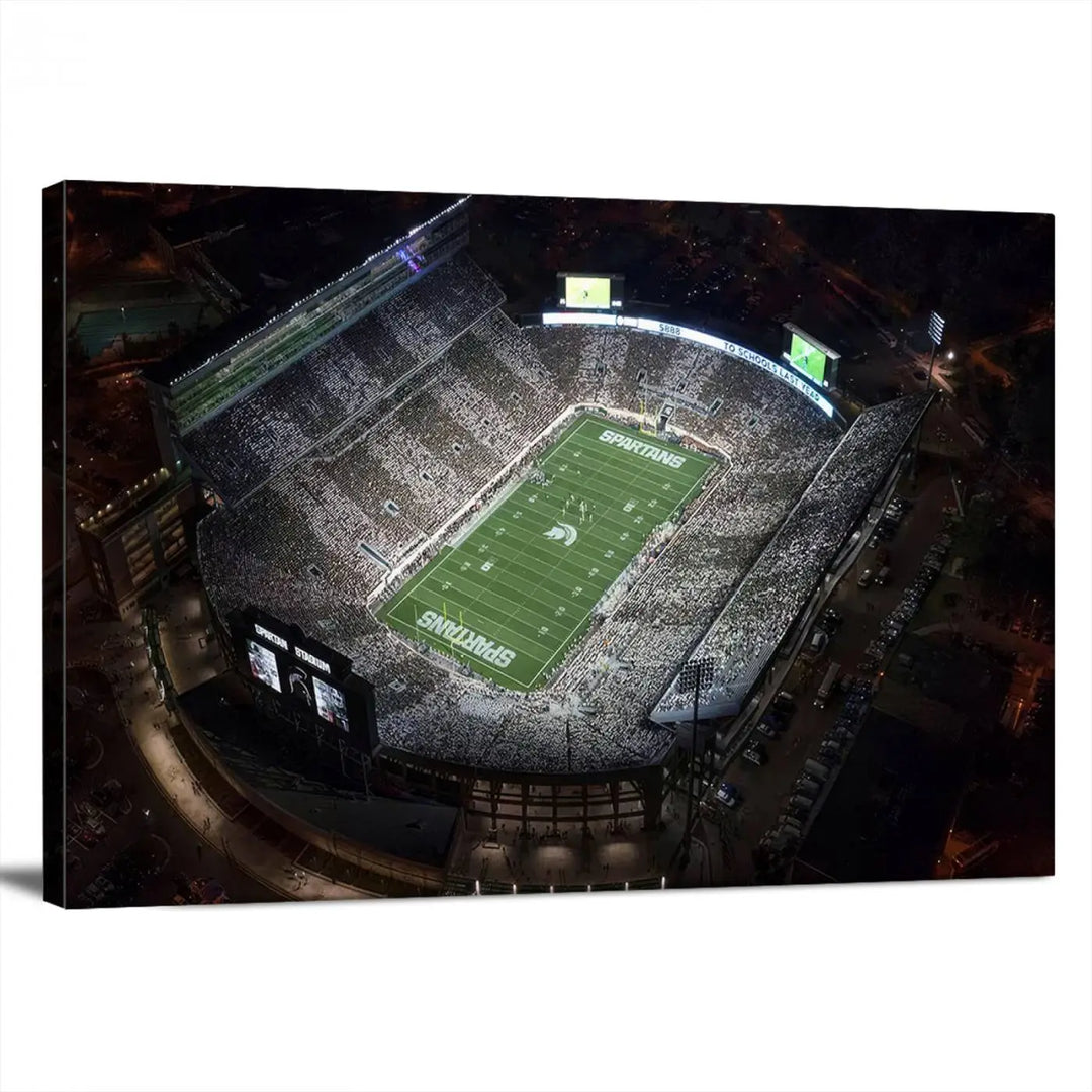 The "Michigan State Spartans Football Team Print - East Lansing Spartan Stadium Wall Art Canvas Print" is elegantly displayed on a wall, showcasing a brightly lit football stadium at night with a gallery-quality finish.