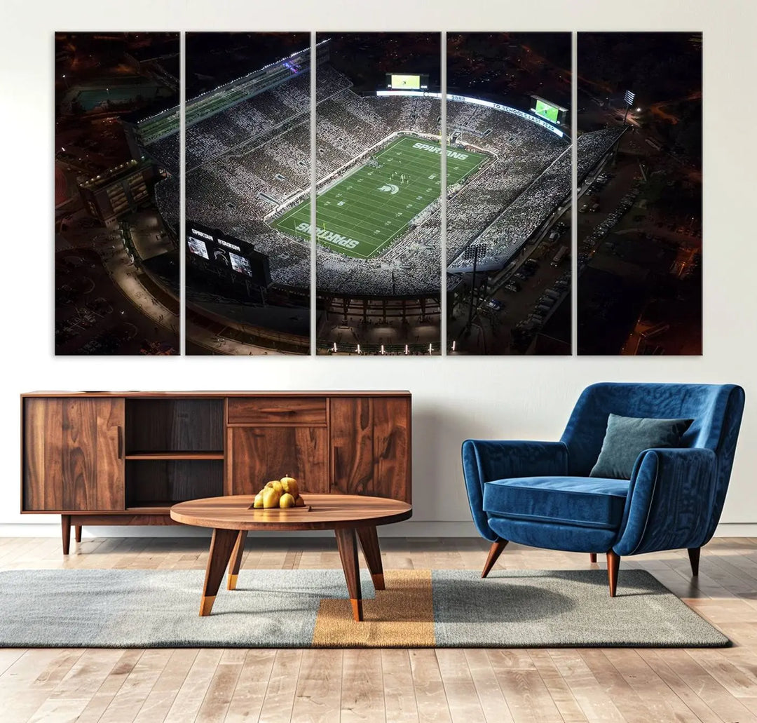 The "Michigan State Spartans Football Team Print - East Lansing Spartan Stadium Wall Art Canvas Print" is elegantly displayed on a wall, showcasing a brightly lit football stadium at night with a gallery-quality finish.