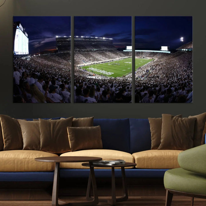 The living room features a wall adorned with a triptych of the Michigan State Spartans Football Team Print - East Lansing Spartan Stadium Wall Art Canvas Print.