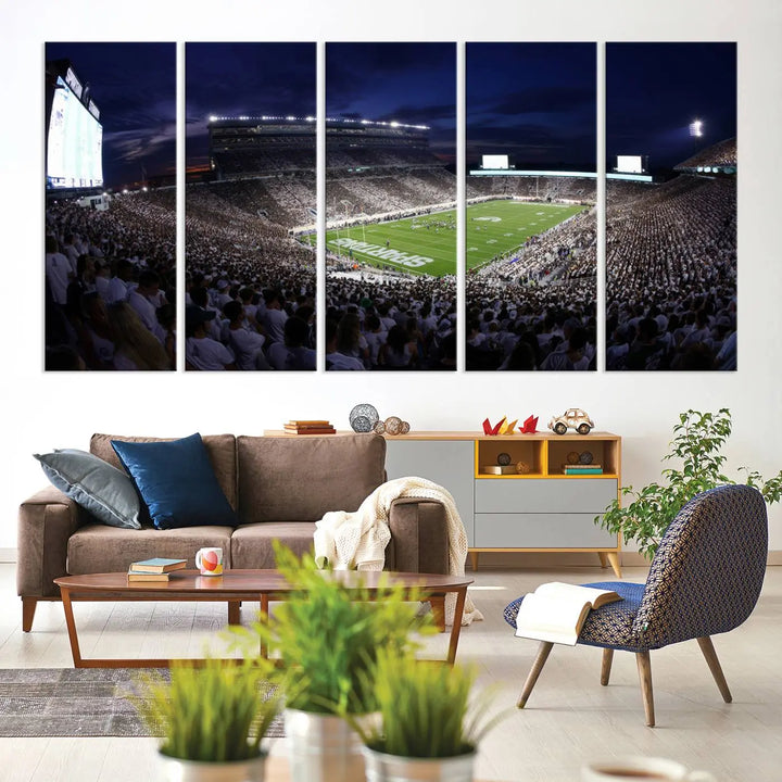 The living room features a wall adorned with a triptych of the Michigan State Spartans Football Team Print - East Lansing Spartan Stadium Wall Art Canvas Print.