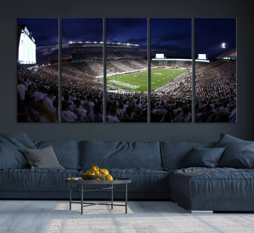 The living room features a wall adorned with a triptych of the Michigan State Spartans Football Team Print - East Lansing Spartan Stadium Wall Art Canvas Print.