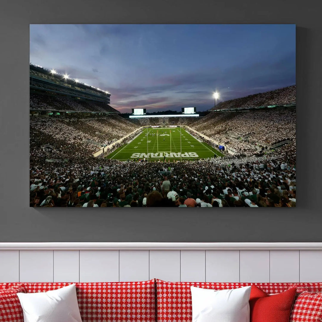 The living room features a Michigan State Spartans Football Team Print, a triptych canvas wall art depicting East Lansing's Spartan Stadium at dusk with a gallery-quality finish.