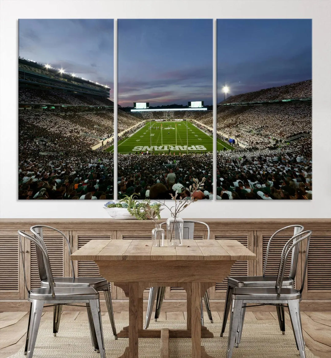 The living room features a Michigan State Spartans Football Team Print, a triptych canvas wall art depicting East Lansing's Spartan Stadium at dusk with a gallery-quality finish.