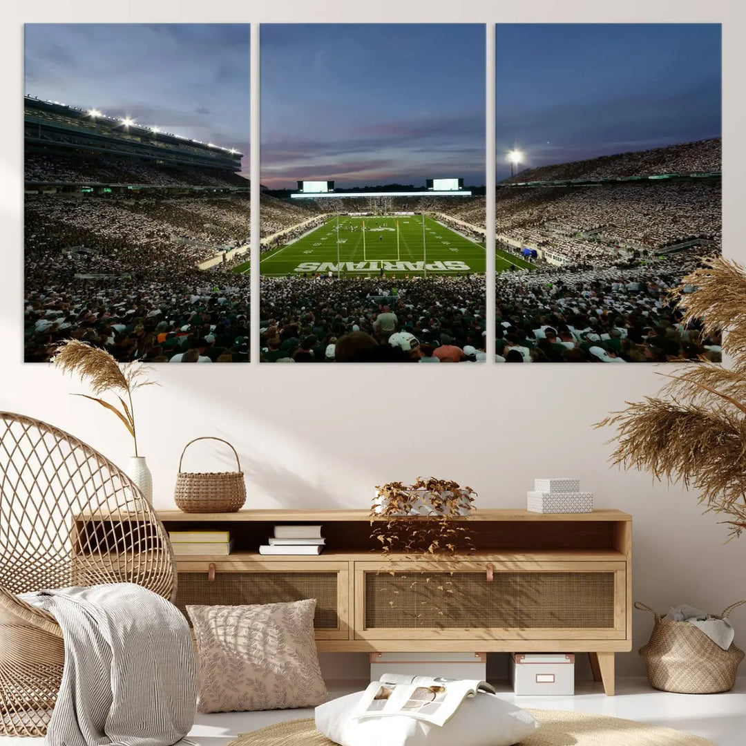 The living room features a Michigan State Spartans Football Team Print, a triptych canvas wall art depicting East Lansing's Spartan Stadium at dusk with a gallery-quality finish.