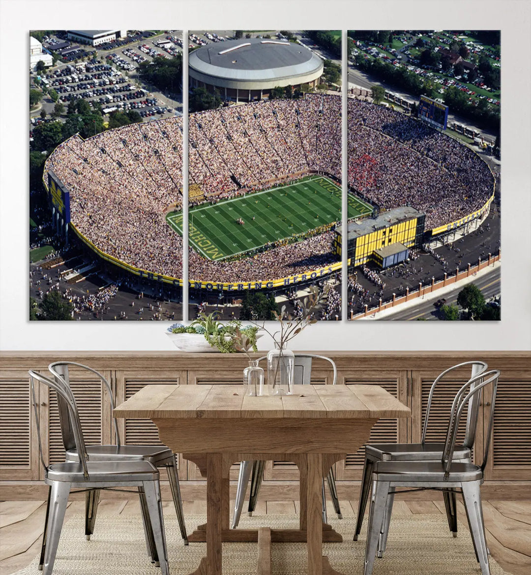 Stunning canvas artwork featuring an aerial view of a packed outdoor football stadium near a dome is beautifully displayed on three large wall panels. This piece, represented by the Michigan Wolverines Football Team Print - Ann Arbor Michigan Stadium Wall Art Canvas Print, offers a gallery-quality finish that enhances its presentation.