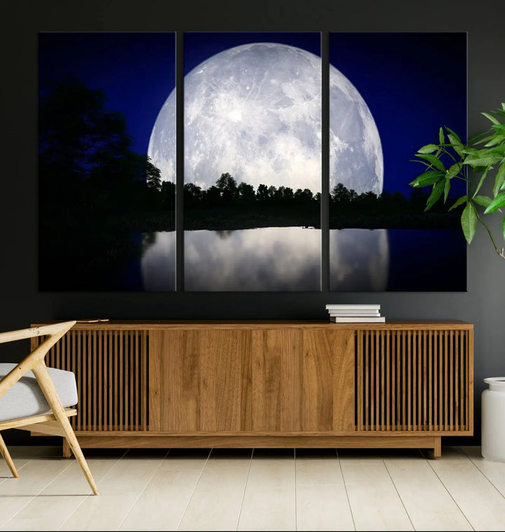 A modern living room showcases a three-panel MoonGlade Wall Art Canvas Print, depicting a moonlit night over a tranquil lake on museum-quality canvases.