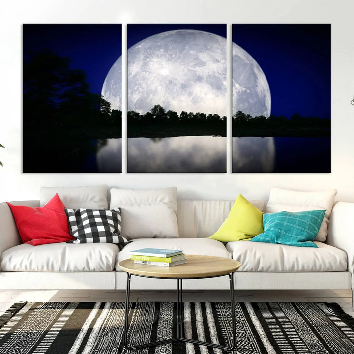 A modern living room showcases a three-panel MoonGlade Wall Art Canvas Print, depicting a moonlit night over a tranquil lake on museum-quality canvases.