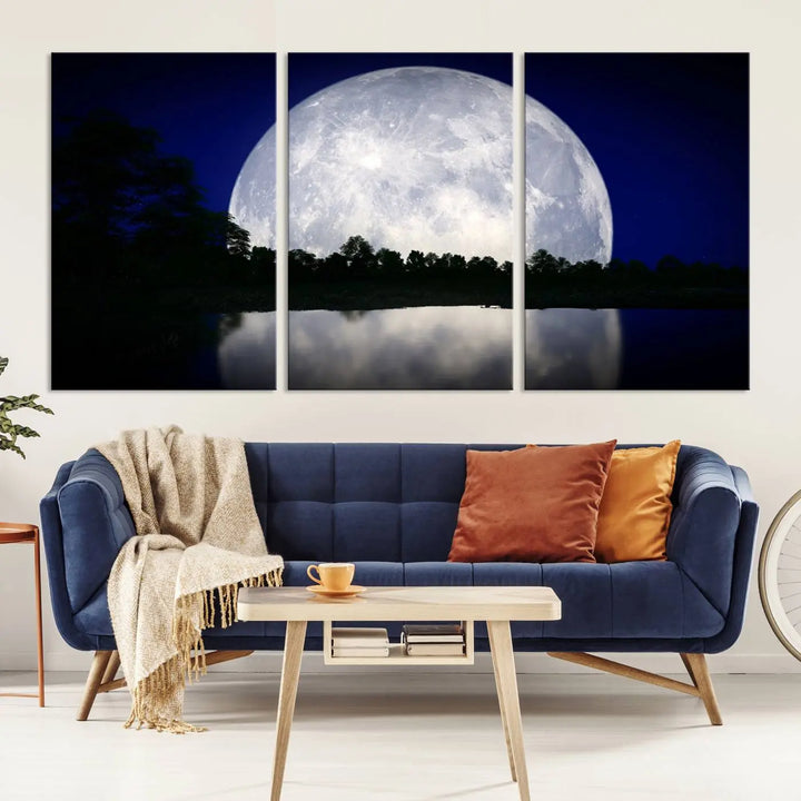 A modern living room showcases a three-panel MoonGlade Wall Art Canvas Print, depicting a moonlit night over a tranquil lake on museum-quality canvases.