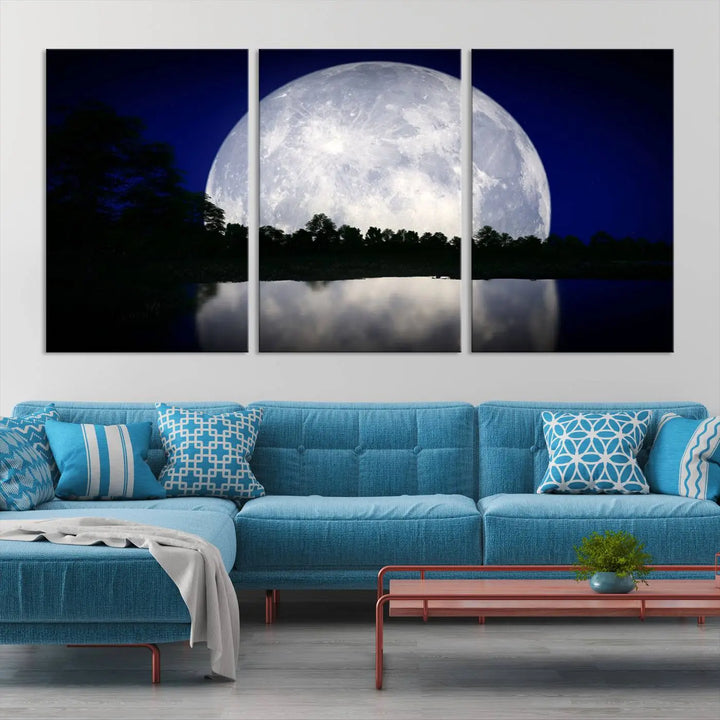 A modern living room showcases a three-panel MoonGlade Wall Art Canvas Print, depicting a moonlit night over a tranquil lake on museum-quality canvases.