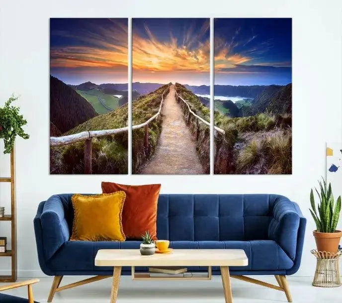 The Mountain and Sunset Wall Art Canvas Print, featuring a three-panel design on museum-quality canvas, captures a stunning sunset over a mountain path with a wooden railing. The hand-assembled frame ensures an exquisite finish and arrives ready to hang, adding natural beauty to any environment.