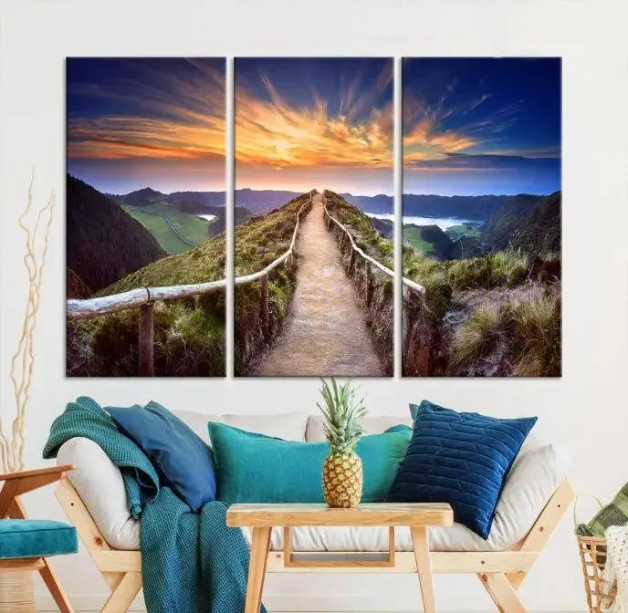 The Mountain and Sunset Wall Art Canvas Print, featuring a three-panel design on museum-quality canvas, captures a stunning sunset over a mountain path with a wooden railing. The hand-assembled frame ensures an exquisite finish and arrives ready to hang, adding natural beauty to any environment.