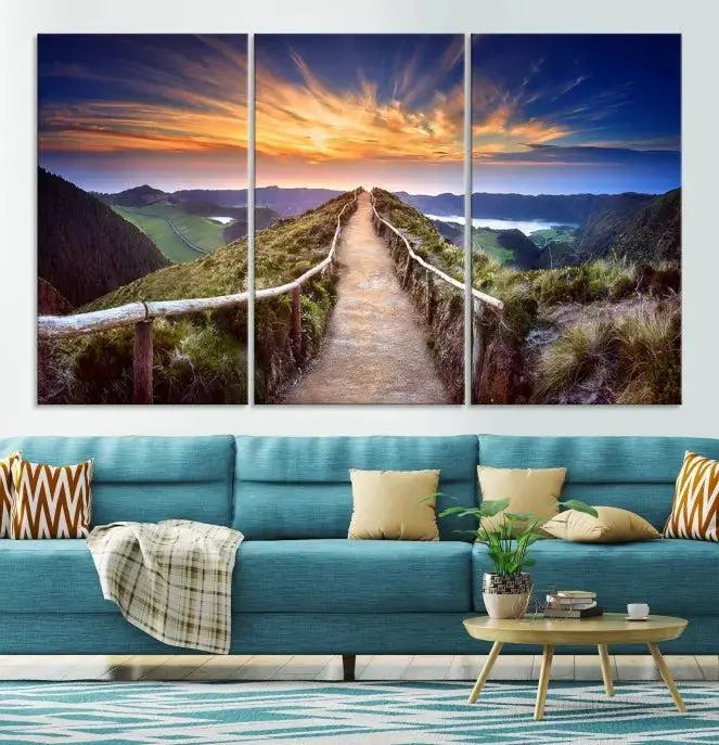 The Mountain and Sunset Wall Art Canvas Print, featuring a three-panel design on museum-quality canvas, captures a stunning sunset over a mountain path with a wooden railing. The hand-assembled frame ensures an exquisite finish and arrives ready to hang, adding natural beauty to any environment.