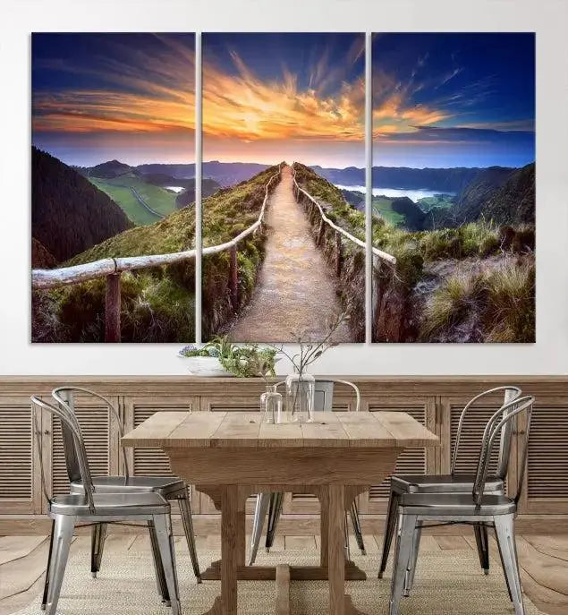 The Mountain and Sunset Wall Art Canvas Print, featuring a three-panel design on museum-quality canvas, captures a stunning sunset over a mountain path with a wooden railing. The hand-assembled frame ensures an exquisite finish and arrives ready to hang, adding natural beauty to any environment.