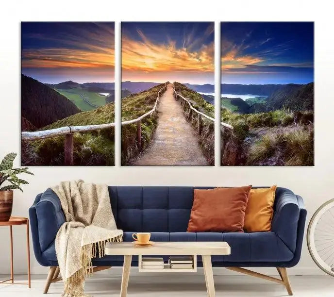 The Mountain and Sunset Wall Art Canvas Print, featuring a three-panel design on museum-quality canvas, captures a stunning sunset over a mountain path with a wooden railing. The hand-assembled frame ensures an exquisite finish and arrives ready to hang, adding natural beauty to any environment.