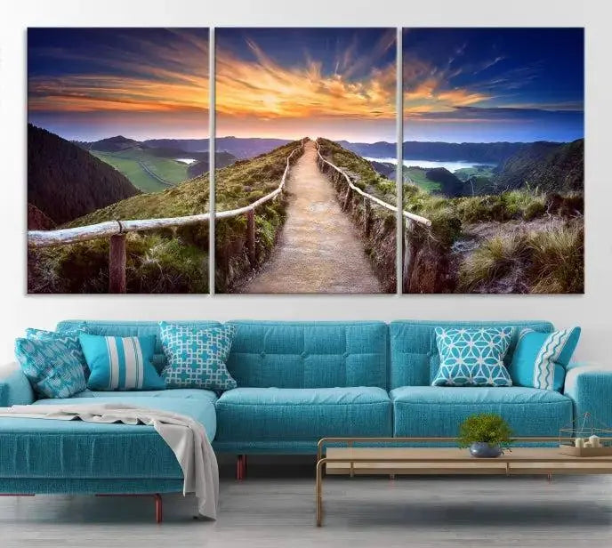 The Mountain and Sunset Wall Art Canvas Print, featuring a three-panel design on museum-quality canvas, captures a stunning sunset over a mountain path with a wooden railing. The hand-assembled frame ensures an exquisite finish and arrives ready to hang, adding natural beauty to any environment.