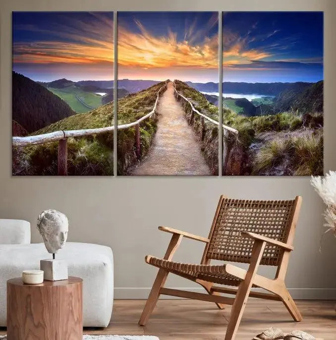 The Mountain and Sunset Wall Art Canvas Print, featuring a three-panel design on museum-quality canvas, captures a stunning sunset over a mountain path with a wooden railing. The hand-assembled frame ensures an exquisite finish and arrives ready to hang, adding natural beauty to any environment.