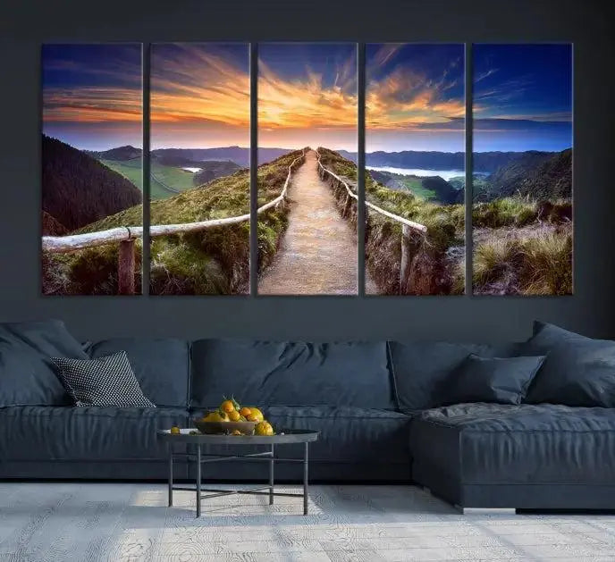 The Mountain and Sunset Wall Art Canvas Print, featuring a three-panel design on museum-quality canvas, captures a stunning sunset over a mountain path with a wooden railing. The hand-assembled frame ensures an exquisite finish and arrives ready to hang, adding natural beauty to any environment.