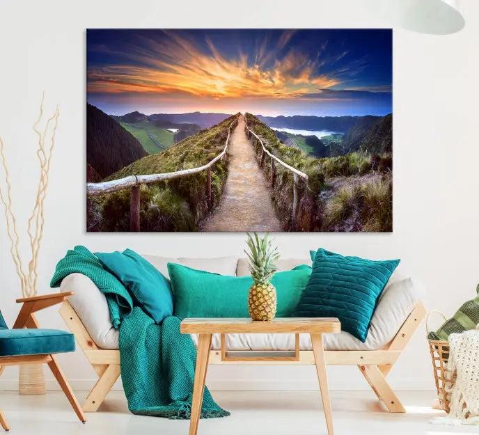 The Mountain and Sunset Wall Art Canvas Print, featuring a three-panel design on museum-quality canvas, captures a stunning sunset over a mountain path with a wooden railing. The hand-assembled frame ensures an exquisite finish and arrives ready to hang, adding natural beauty to any environment.