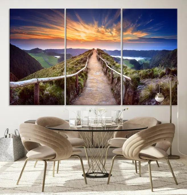 The Mountain and Sunset Wall Art Canvas Print, featuring a three-panel design on museum-quality canvas, captures a stunning sunset over a mountain path with a wooden railing. The hand-assembled frame ensures an exquisite finish and arrives ready to hang, adding natural beauty to any environment.