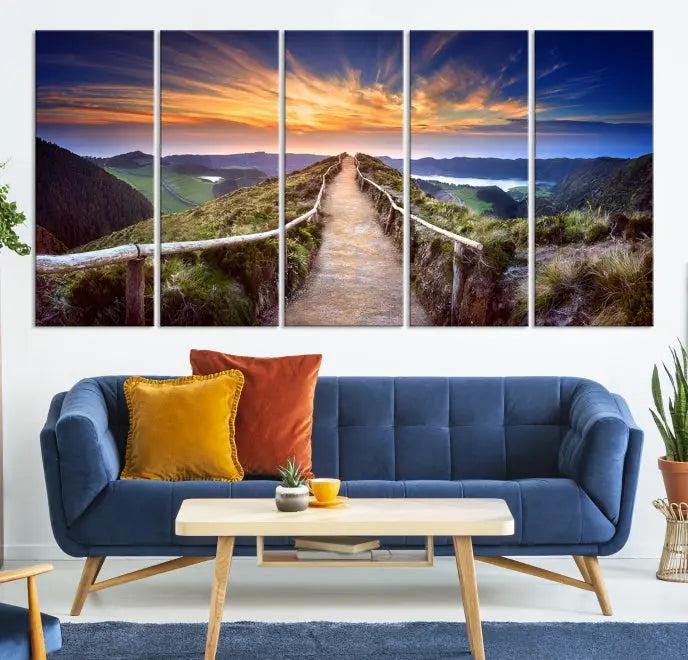 The Mountain and Sunset Wall Art Canvas Print, featuring a three-panel design on museum-quality canvas, captures a stunning sunset over a mountain path with a wooden railing. The hand-assembled frame ensures an exquisite finish and arrives ready to hang, adding natural beauty to any environment.