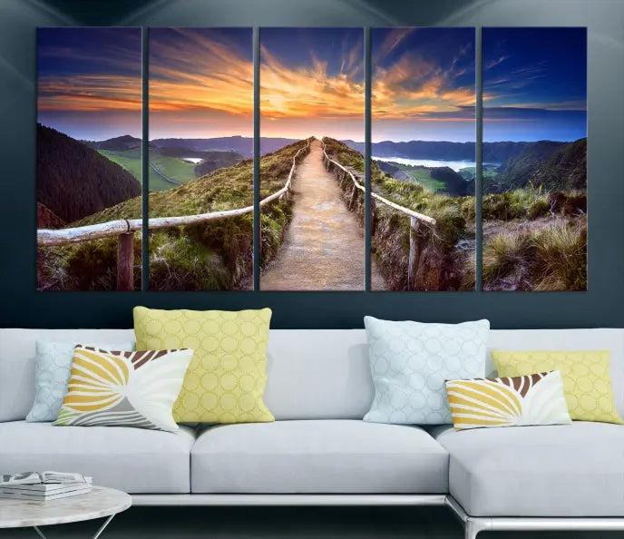 The Mountain and Sunset Wall Art Canvas Print, featuring a three-panel design on museum-quality canvas, captures a stunning sunset over a mountain path with a wooden railing. The hand-assembled frame ensures an exquisite finish and arrives ready to hang, adding natural beauty to any environment.