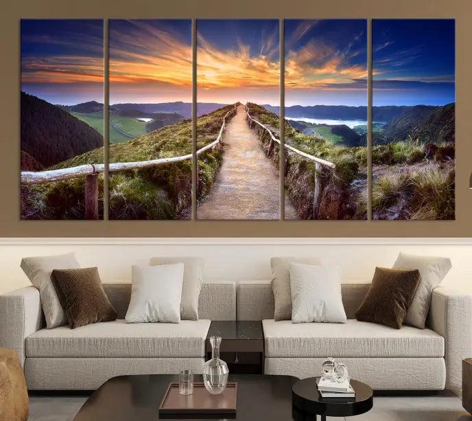 The Mountain and Sunset Wall Art Canvas Print, featuring a three-panel design on museum-quality canvas, captures a stunning sunset over a mountain path with a wooden railing. The hand-assembled frame ensures an exquisite finish and arrives ready to hang, adding natural beauty to any environment.