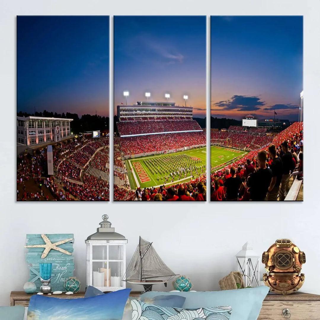 A thrilling college football game is captured in the NC State Wolfpack Football Team Print, featuring a triptych wall art of the packed Carter-Finley Stadium at sunset, showcasing NC State Wolfpack fans and players on the field.