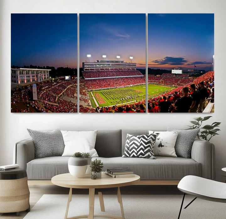 A thrilling college football game is captured in the NC State Wolfpack Football Team Print, featuring a triptych wall art of the packed Carter-Finley Stadium at sunset, showcasing NC State Wolfpack fans and players on the field.