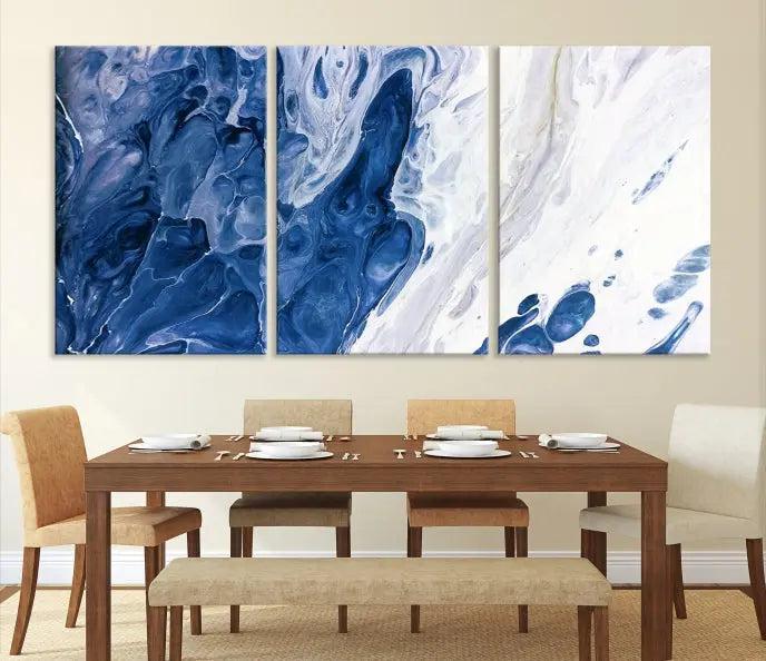 The "Navy Blue Marble Fluid Effect Wall Art Abstract Canvas Wall Art Print" is a striking triptych piece featuring swirling blue and white patterns, crafted on museum-quality polycotton canvas. Enhanced with a UV-protective coating, this artwork stands out in any setting.