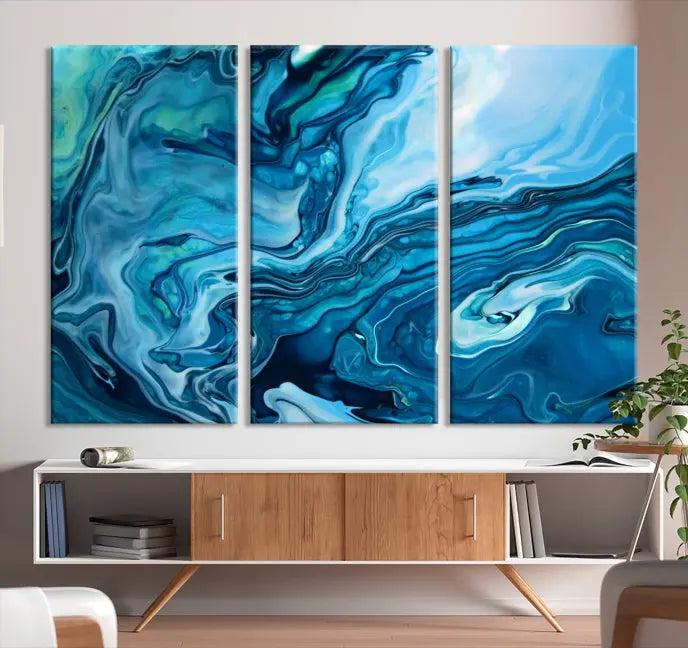 A triptych of the Navy Blue Marble Fluid Effect Wall Art Abstract Canvas Print, featuring swirling blue patterns, graces the space. These pieces are crafted on museum-quality canvas and gallery wrapped with a UV-protective coating to ensure longevity.