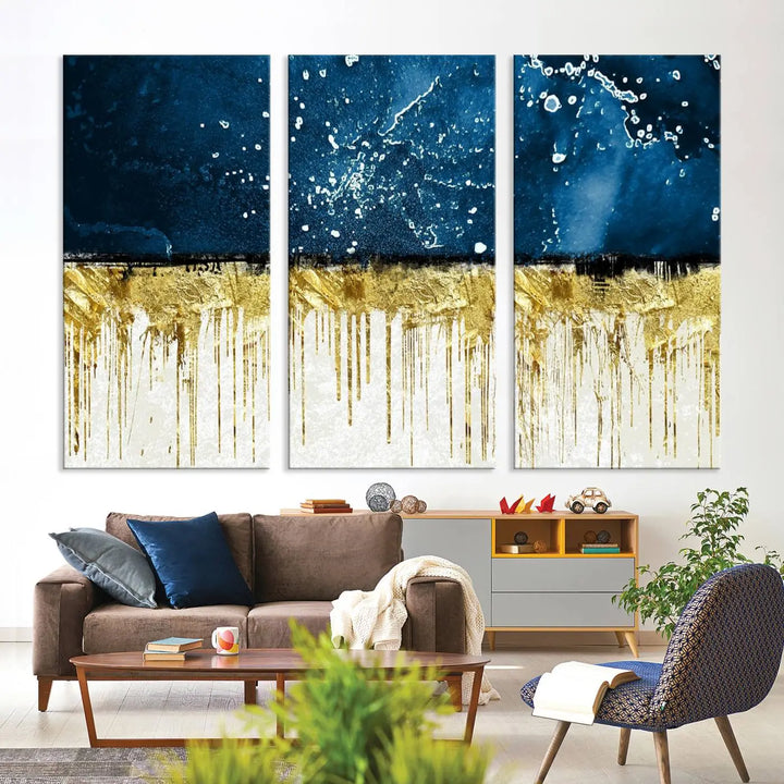 The Navy Blue Marble Fluid Effect Wall Art Abstract Canvas Print, a three-panel piece featuring blue, gold, and white colors on gallery-wrapped canvas, adorns the wall in a modern room. The museum-quality canvas ensures an elegant touch.