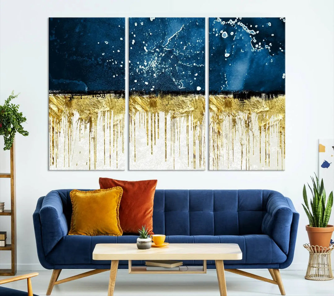 The Navy Blue Marble Fluid Effect Wall Art Abstract Canvas Print, a three-panel piece featuring blue, gold, and white colors on gallery-wrapped canvas, adorns the wall in a modern room. The museum-quality canvas ensures an elegant touch.