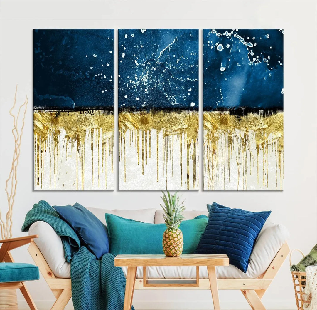 The Navy Blue Marble Fluid Effect Wall Art Abstract Canvas Print, a three-panel piece featuring blue, gold, and white colors on gallery-wrapped canvas, adorns the wall in a modern room. The museum-quality canvas ensures an elegant touch.