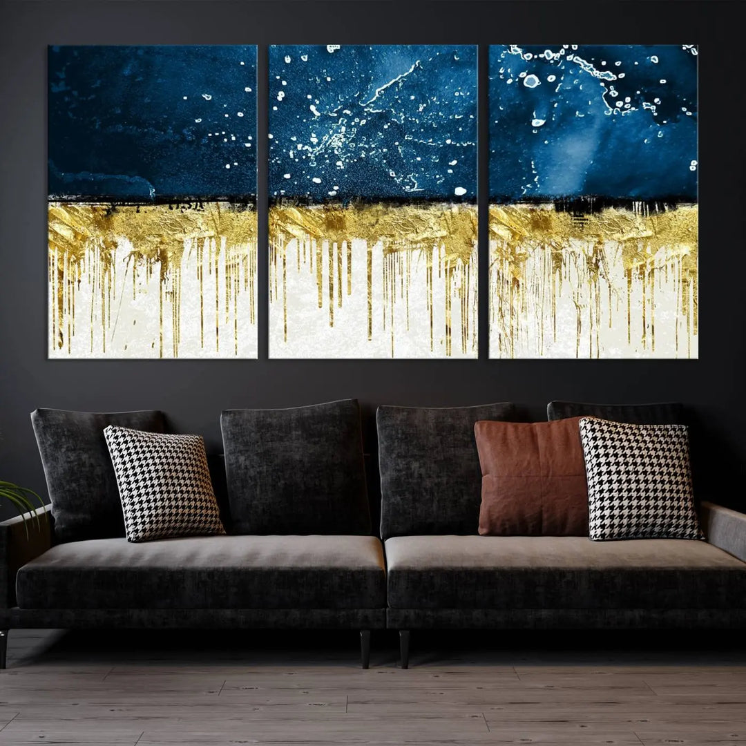 The Navy Blue Marble Fluid Effect Wall Art Abstract Canvas Print, a three-panel piece featuring blue, gold, and white colors on gallery-wrapped canvas, adorns the wall in a modern room. The museum-quality canvas ensures an elegant touch.