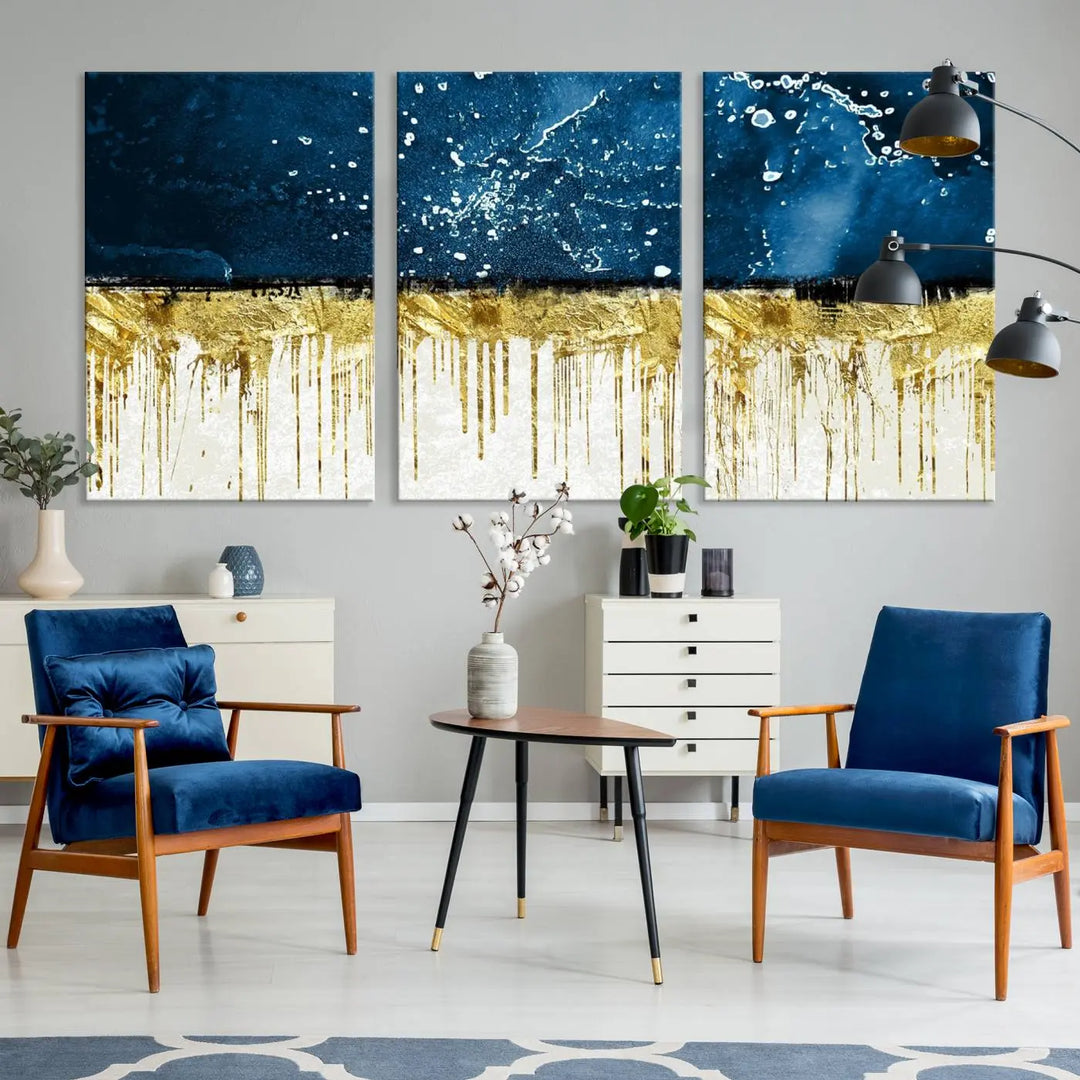 The Navy Blue Marble Fluid Effect Wall Art Abstract Canvas Print, a three-panel piece featuring blue, gold, and white colors on gallery-wrapped canvas, adorns the wall in a modern room. The museum-quality canvas ensures an elegant touch.