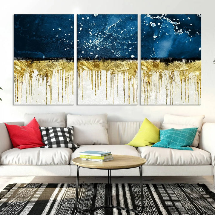 The Navy Blue Marble Fluid Effect Wall Art Abstract Canvas Print, a three-panel piece featuring blue, gold, and white colors on gallery-wrapped canvas, adorns the wall in a modern room. The museum-quality canvas ensures an elegant touch.