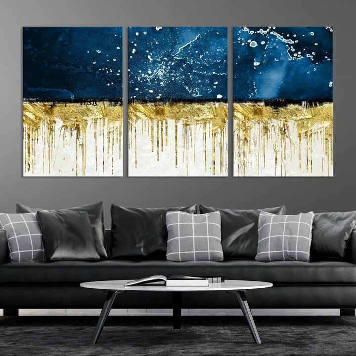 The Navy Blue Marble Fluid Effect Wall Art Abstract Canvas Print, a three-panel piece featuring blue, gold, and white colors on gallery-wrapped canvas, adorns the wall in a modern room. The museum-quality canvas ensures an elegant touch.