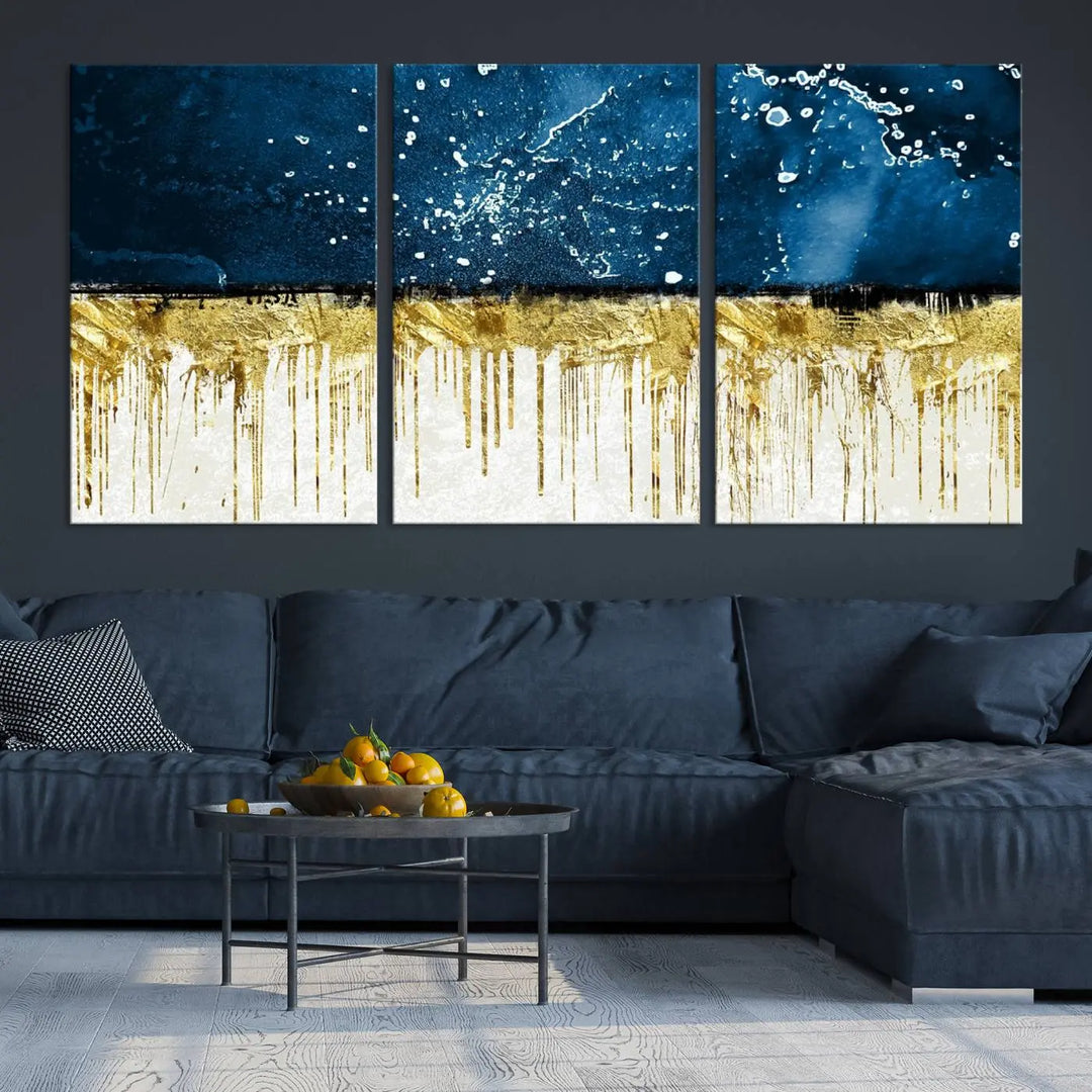 The Navy Blue Marble Fluid Effect Wall Art Abstract Canvas Print, a three-panel piece featuring blue, gold, and white colors on gallery-wrapped canvas, adorns the wall in a modern room. The museum-quality canvas ensures an elegant touch.