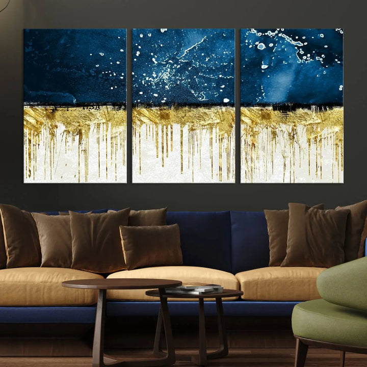 The Navy Blue Marble Fluid Effect Wall Art Abstract Canvas Print, a three-panel piece featuring blue, gold, and white colors on gallery-wrapped canvas, adorns the wall in a modern room. The museum-quality canvas ensures an elegant touch.