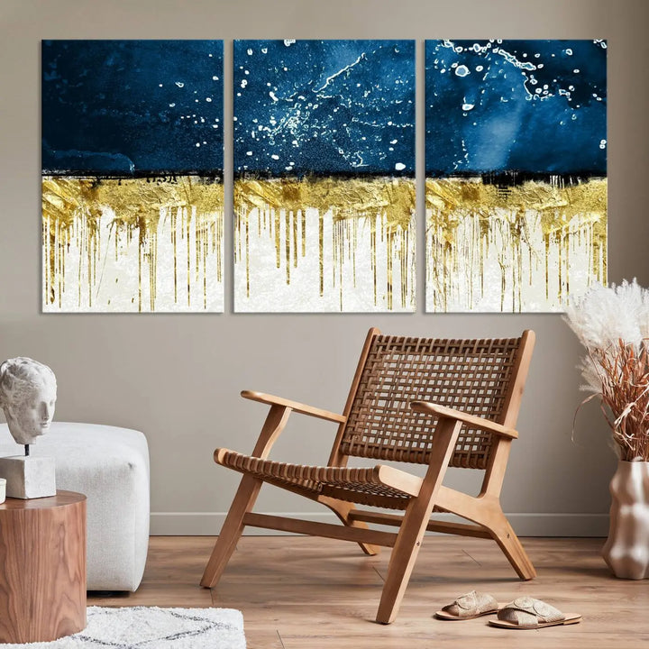 The Navy Blue Marble Fluid Effect Wall Art Abstract Canvas Print, a three-panel piece featuring blue, gold, and white colors on gallery-wrapped canvas, adorns the wall in a modern room. The museum-quality canvas ensures an elegant touch.