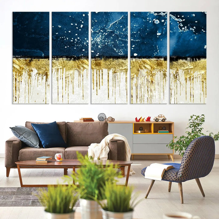 The Navy Blue Marble Fluid Effect Wall Art Abstract Canvas Print, a three-panel piece featuring blue, gold, and white colors on gallery-wrapped canvas, adorns the wall in a modern room. The museum-quality canvas ensures an elegant touch.