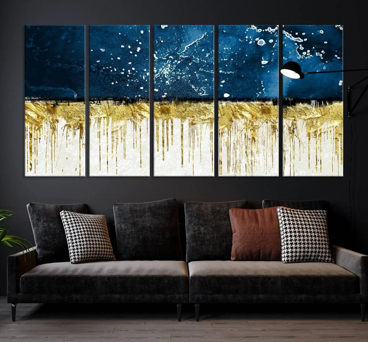 The Navy Blue Marble Fluid Effect Wall Art Abstract Canvas Print, a three-panel piece featuring blue, gold, and white colors on gallery-wrapped canvas, adorns the wall in a modern room. The museum-quality canvas ensures an elegant touch.