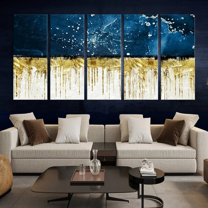 The Navy Blue Marble Fluid Effect Wall Art Abstract Canvas Print, a three-panel piece featuring blue, gold, and white colors on gallery-wrapped canvas, adorns the wall in a modern room. The museum-quality canvas ensures an elegant touch.