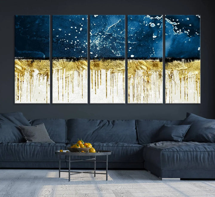 The Navy Blue Marble Fluid Effect Wall Art Abstract Canvas Print, a three-panel piece featuring blue, gold, and white colors on gallery-wrapped canvas, adorns the wall in a modern room. The museum-quality canvas ensures an elegant touch.