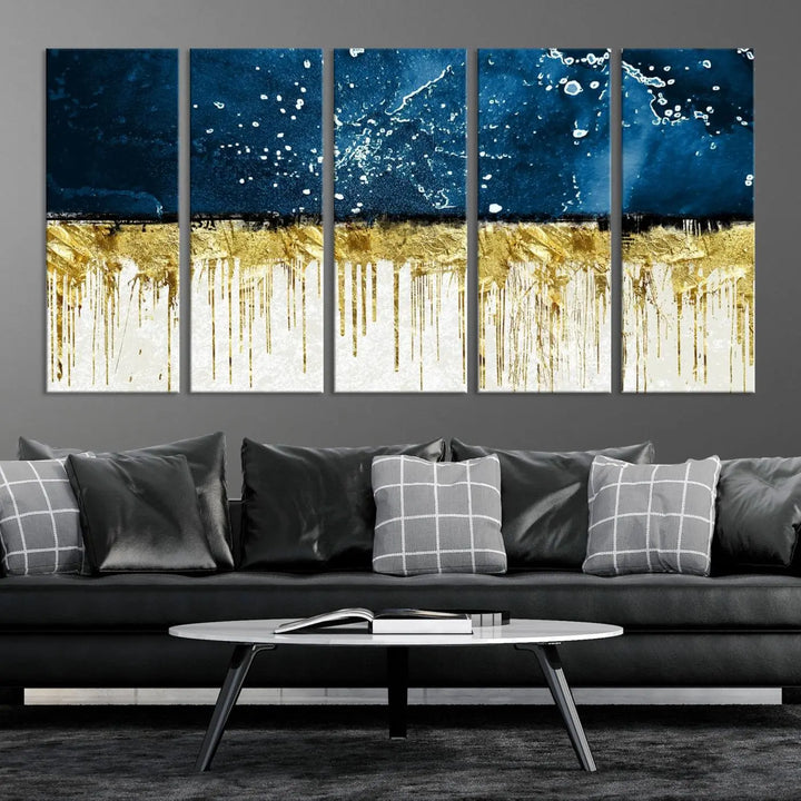 The Navy Blue Marble Fluid Effect Wall Art Abstract Canvas Print, a three-panel piece featuring blue, gold, and white colors on gallery-wrapped canvas, adorns the wall in a modern room. The museum-quality canvas ensures an elegant touch.