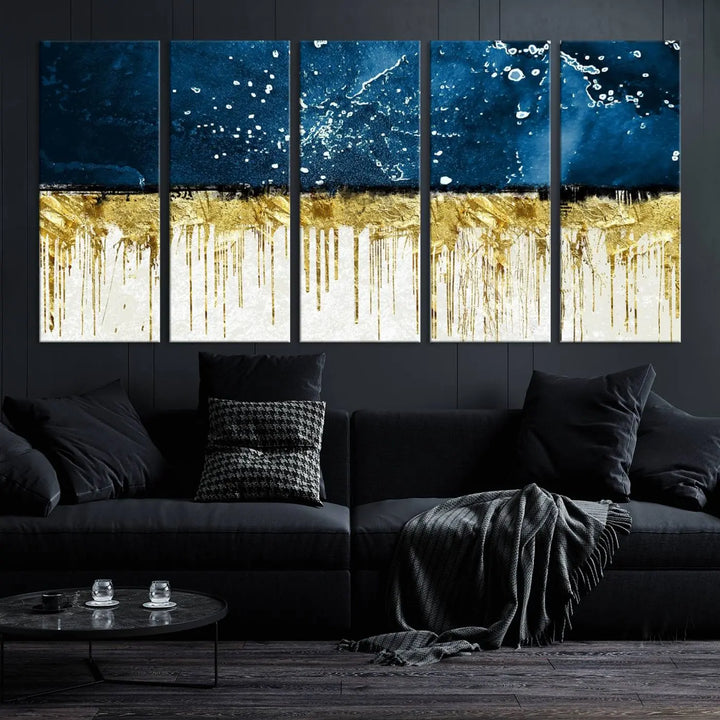 The Navy Blue Marble Fluid Effect Wall Art Abstract Canvas Print, a three-panel piece featuring blue, gold, and white colors on gallery-wrapped canvas, adorns the wall in a modern room. The museum-quality canvas ensures an elegant touch.