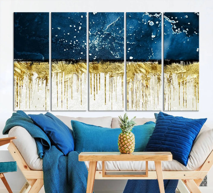 The Navy Blue Marble Fluid Effect Wall Art Abstract Canvas Print, a three-panel piece featuring blue, gold, and white colors on gallery-wrapped canvas, adorns the wall in a modern room. The museum-quality canvas ensures an elegant touch.